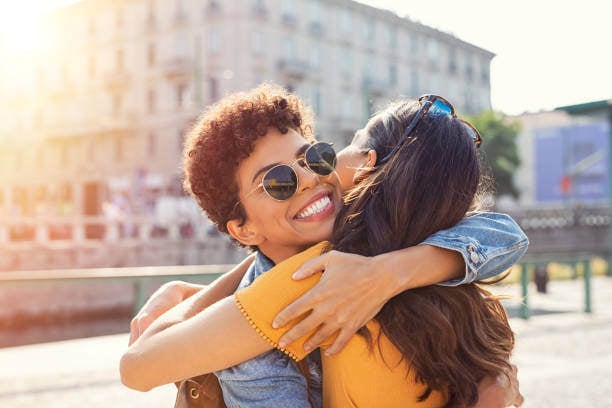 dos-mujeres-abrazándose-en-la-plaza